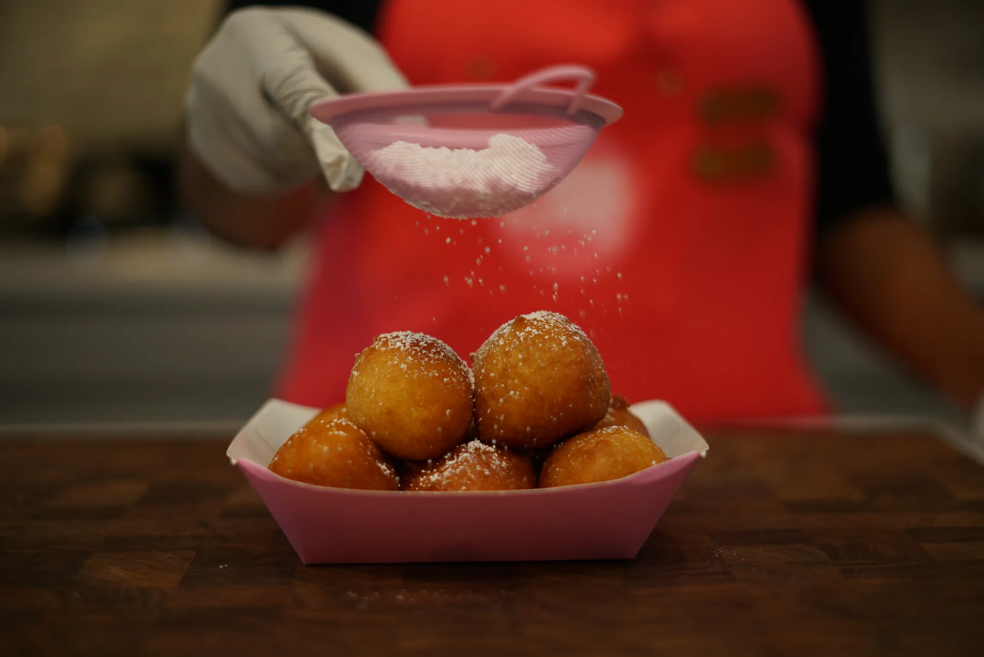Fresh Puff Puffs being dusted with powdered sugar